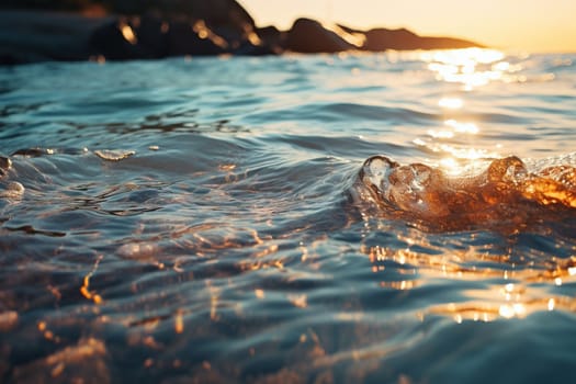Sea water splashes near the shore in the rays of sunset.