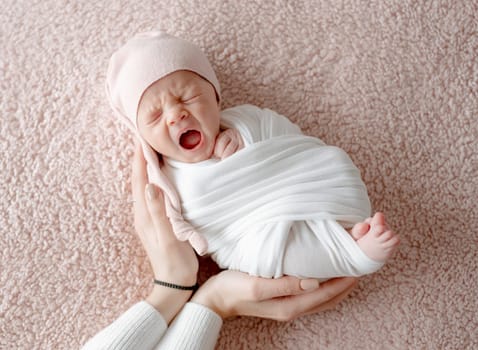 Newborn Baby Yawns In Sleep While Mother'S Gentle Hands Hold Him During Newborn Photoshoot