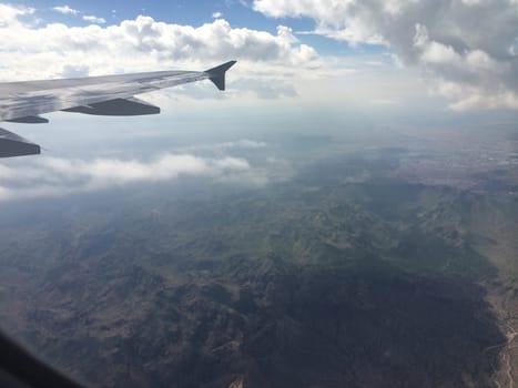 View from Airplane Window of Mountains and Clouds. High quality photo