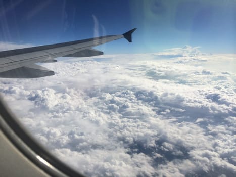 View from Airplane Window above the Clouds. Cell phone reflection. High quality photo