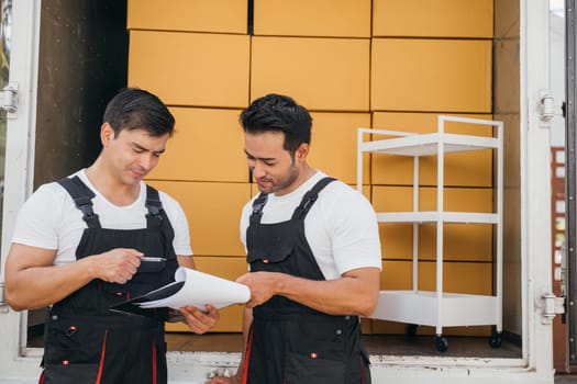 Employees outdoors unloading boxes and checking documents for the relocation company. Their teamwork guarantees a smooth move and efficient delivery. Moving Day