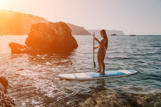 Close up shot of happy young caucasian woman looking at camera and smiling. Cute woman portrait in bikini posing on a volcanic rock high above the sea