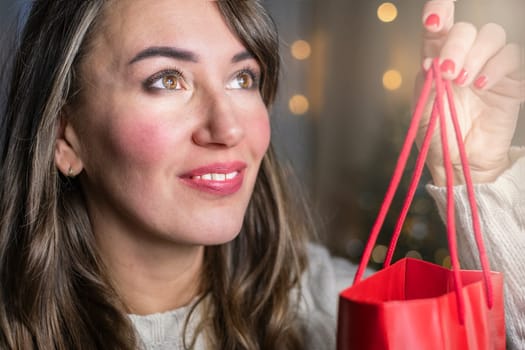 Happy woman holding gift box. Portrait of beautiful smiling woman holding a gift.