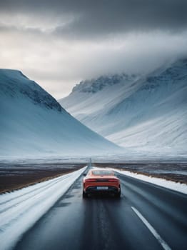 A red car makes its way along a snowy road surrounded by a serene winter landscape.