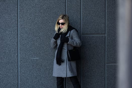 A young girl blonde walks through the city.