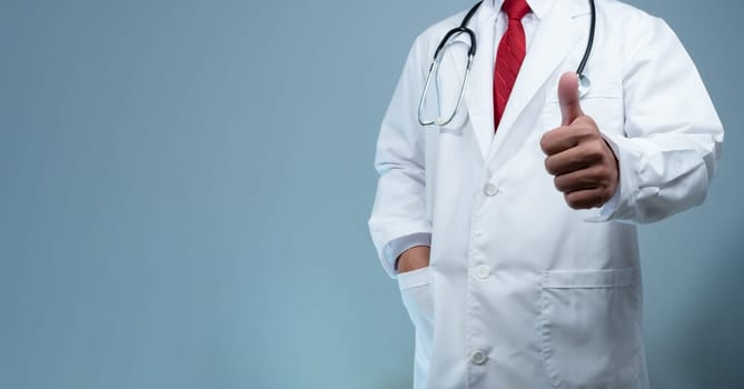 Doctor in lab coat gives thumbs up on light gray background