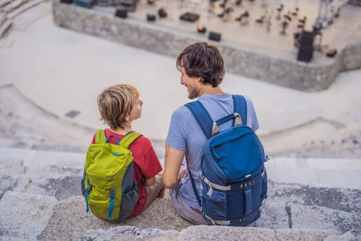 Father and son tourists explores Aspendos Ancient City. Traveling with kids concept. Aspendos acropolis city ruins, cisterns, aqueducts and old temple. Aspendos Antalya Turkey. turkiye.