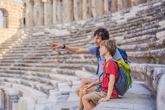 Father and son tourists explores Aspendos Ancient City. Traveling with kids concept. Aspendos acropolis city ruins, cisterns, aqueducts and old temple. Aspendos Antalya Turkey. turkiye.