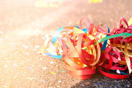 Colorful confetti and streamers at the street after Carnival parade. Italy