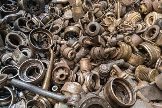 rusted steel scrap pile of used car parts and pieces - full-frame closeup background and texture