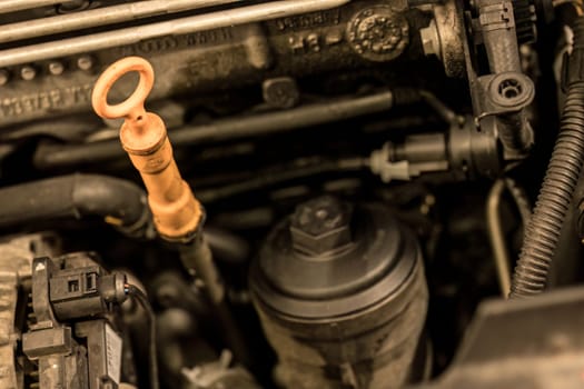 Photo of an oil dipstick in a car engine, symbolizing the crucial need for regular engine maintenance.