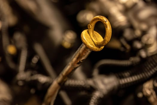 A photo capturing the moment of checking oil level with a dipstick in a car engine for routine maintenance.