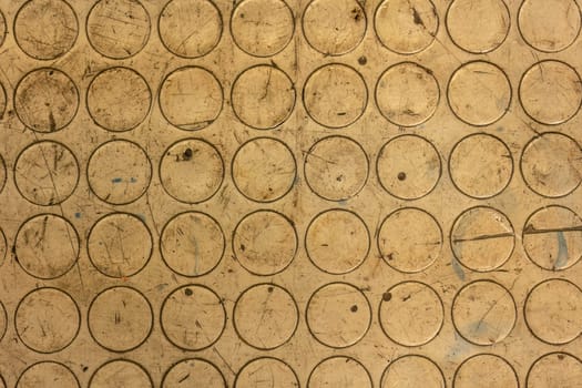 Photo of a grimy rubber mat texture on a mechanical workshop bench, depicting everyday wear and tear.