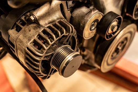 Detailed image of an alternator pulley attached to a car engine, showcasing intricate mechanical parts.