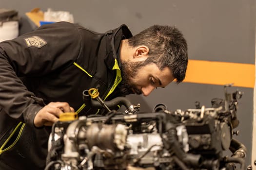 Rome, Italy 17 january 2024: A mechanic meticulously examining a car engine, showcasing expertise in automotive diagnostics.