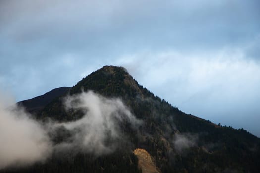 Mountain Majesty: A Lone Peak Rising Through the Veil of Morning Mist. High quality photo