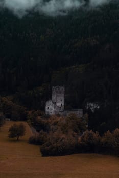 Mysteries of History: The Silent Vigil of an Ancient Castle Amidst Autumn's Forest Cloak. High quality photo