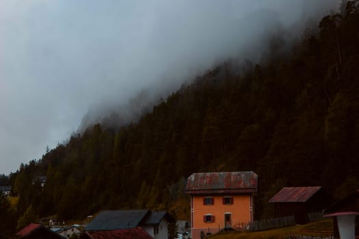 Autumnal Alpine Elegance: A Heritage House Against the Fiery Hues of a Forested Hillside. High quality photo