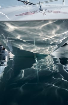 Monaco, Monte-Carlo, 26 October 2022: Logo of new Yacht Club on glossy board of moored sail boat, azure water, tranquillity in port Hercules at sunny day. High quality 4k footage