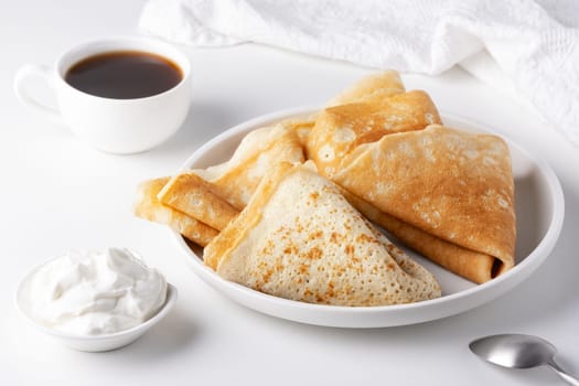 Thin pancakes in a plate. Concept of delicious breakfast or Maslenitsa.