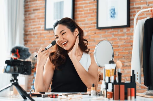 Woman influencer shoot live streaming vlog video review makeup uttermost social media or blog. Happy young girl with cosmetics studio lighting for marketing recording session broadcasting online.