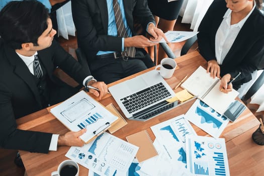 Diverse group of business analyst team analyzing financial data report paper on office table. Chart and graph dashboard by business intelligence analysis for strategic marketing planning Habiliment