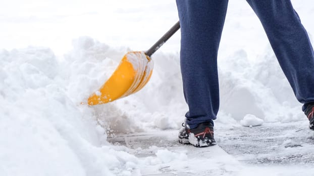 Man shoveling snow off of his driveway after a winter storm in Canada. Man with snow shovel cleans sidewalks in winter. Winter time