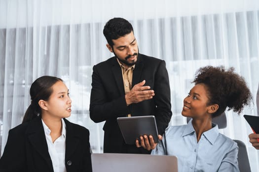 Happy diverse business people work together, discussing in corporate office. Professional and diversity teamwork discuss business plan on desk with laptop. Modern multicultural office worker. Concord