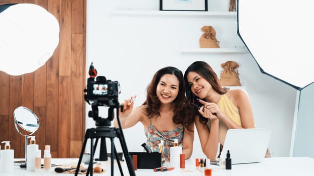 Woman influencer shoot live streaming vlog video review makeup uttermost social media or blog. Happy young girl with cosmetics studio lighting for marketing recording session broadcasting online.