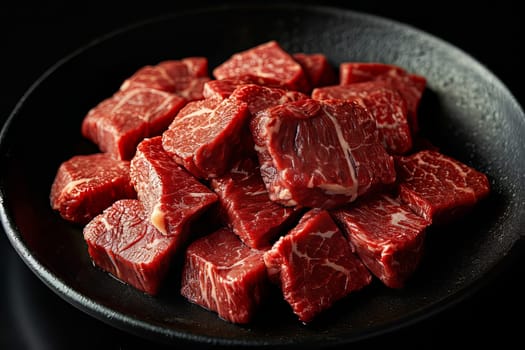 Beef, cut into many identical pieces for cooking, lies on a black plate on a black surface. AI generated.