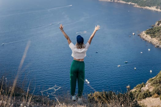 Happy woman standing with her back in nature in summer with open hands posing with mountains. Woman in the mountains, eco friendly, summer landscape active rest.