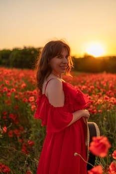 Woman poppy field red dress sunset. Happy woman in a long red dress in a beautiful large poppy field. Blond stands with her back posing on a large field of red poppies.