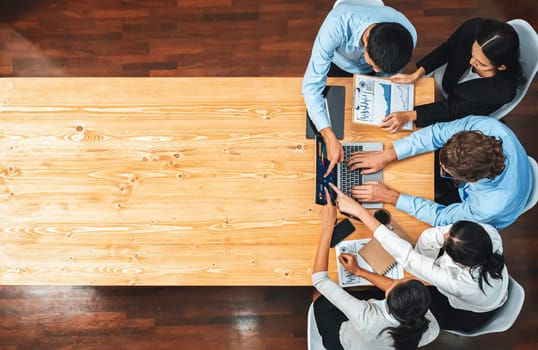 Panorama top view diverse group of business analyst team analyzing financial data report paper on meeting table. Chart and graph dashboard by business intelligence analysis. Meticulous