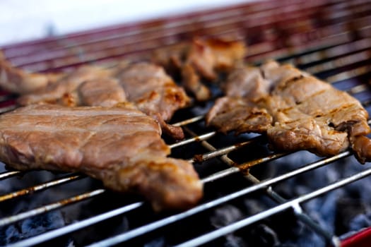 Grilling steaks on charcoal Barbecue grill outdoors in yard.