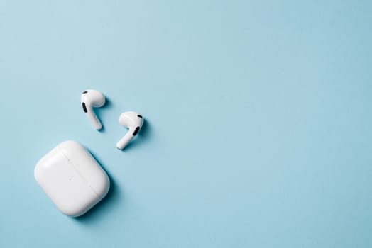 Wireless headphones and charging box, photographed leaving empty space on the right side of the photo