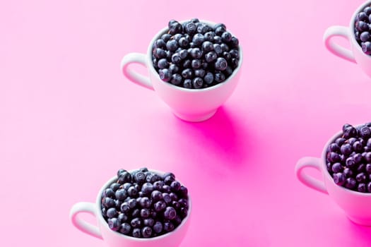 Fresh organic blueberries in a paper cup on a white background. Copy space, isolated, high resolution
