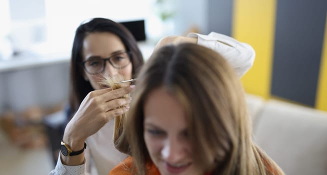 Portrait of friend cutting hair with scissors tool, ask friend to help with image change. Wellness, beauty day, friendship, experiment, fun, bff concept