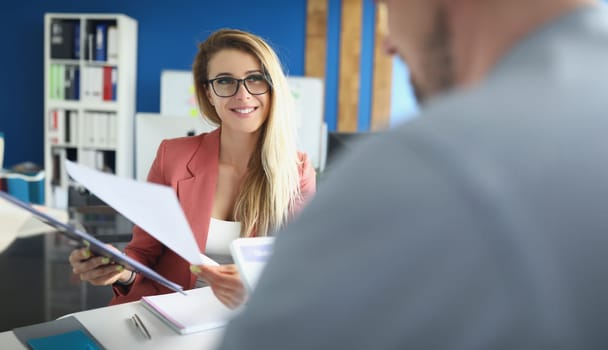 Portrait of optimistic woman discuss business papers with colleague, lady boss. Woman happy about company results. Business, career growth, success concept