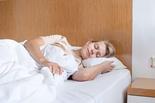 Feeling calmness. Sleepy female keeping eyes closed sleeping at hotel room.