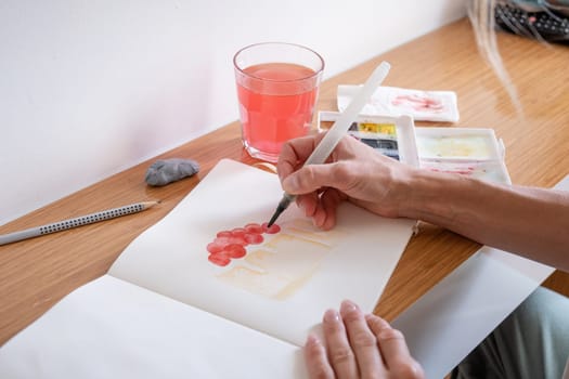 Hobbies and leisure. unrecognizable woman drawing watercolor on hotel room table