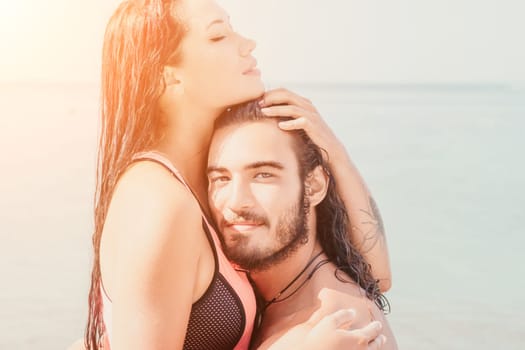 Close up shot of beautiful young caucasian woman with black hair and freckles looking at camera and smiling. Cute woman portrait in a pink bikini posing on a volcanic rock high above the sea