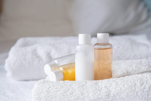 Travel cosmetics kit with bottles, pills and cosmetics on bed , top view