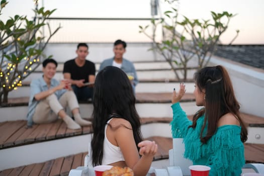 Young people having fun hanging out on weekend together on a rooftop.