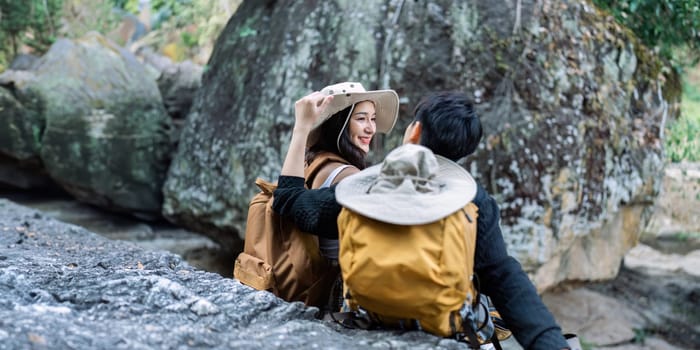 Lesbian couple relaxing together on rock at a hiking trail While traveling together on a hiking trail.