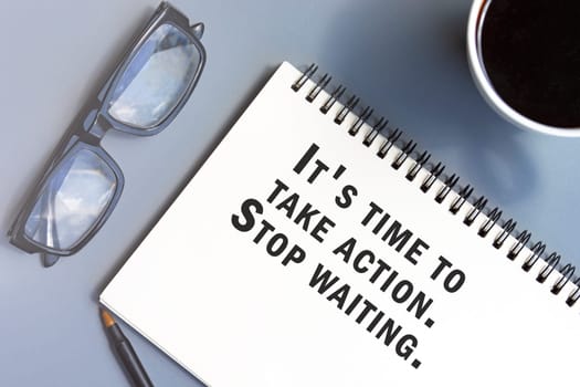 Motivational and inspirational quote on notepad - It is time to take action. Stop waiting.