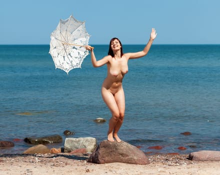 Youth, beauty and nudity. Young naked woman enjoying nature on the seashore