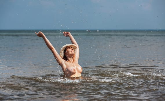 Youth, beauty and nudity. Young naked woman enjoying nature on the seashore