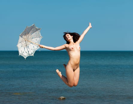 Youth, beauty and nudity. Young naked woman enjoying nature on the seashore