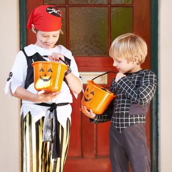 Halloween, candy and door with children in costume on porch for trick or treat celebration together. Friends, food and sweets with young boy kids in fancy dress for spooky holiday or vacation.