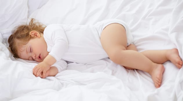 Baby, kid and sleeping on bed for calm break, peace and dream to relax at home from above. Tired, cozy or young child asleep for newborn development, healthy childhood growth and rest in nursery room.